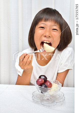 フルーツを美味しそうに食べる女の子の写真素材 フルーツを美味しそうに食べる女の子の写真素材
