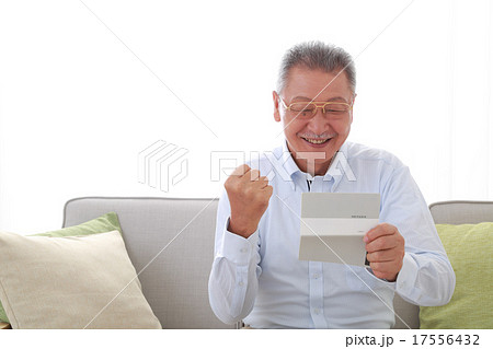 通帳を見て喜ぶシニア男性 17556432