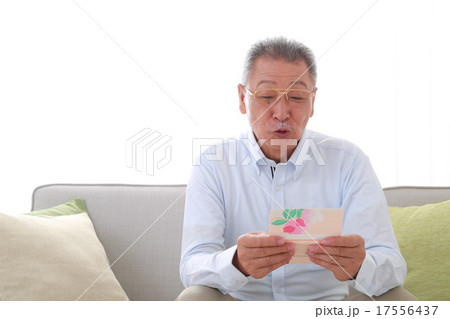 銀行通帳を見て喜ぶシニア男性 17556437