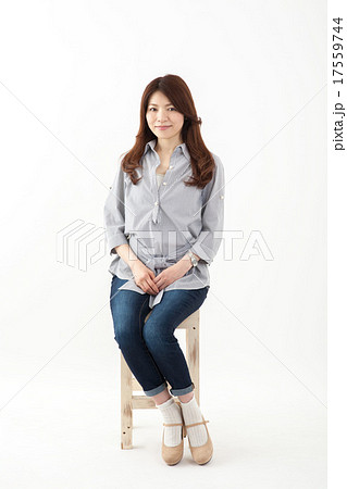 中年女性 日本人 笑顔のミドル女性 椅子 全身の写真素材