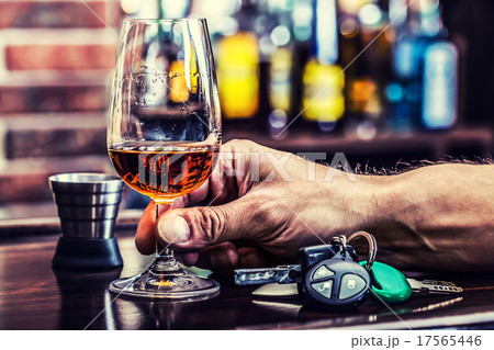 Alcoholism. Cup cognac or brandy hand man the keys Alcoholism. Cup cognac or brandy hand man the keys 17565446