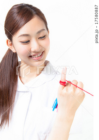 小指に赤い糸を結んだ看護婦 目線外しの写真素材