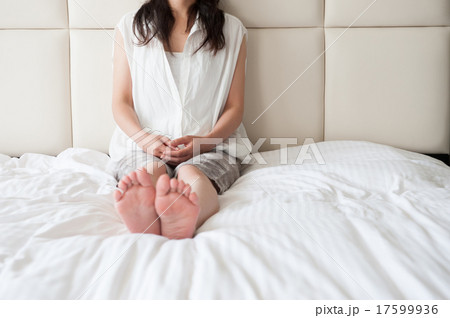 ベッドの上で寂しく座っている女性 17599936