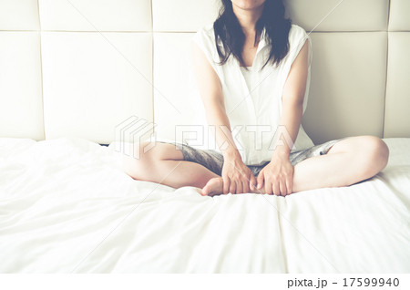 ベッドの上で寂しく座っている女性 17599940
