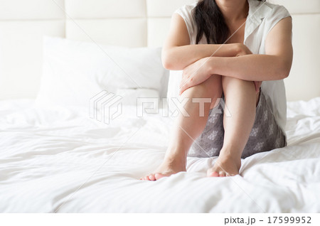 ベッドの上で寂しく座っている女性の写真素材 [17599952] - PIXTA