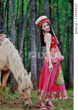 白馬と美人女性モデル ポーズ撮影 中国雲南省麗江 民族衣装 黒髪ストレートモデルの写真素材