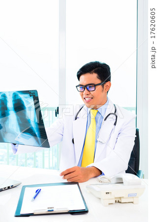 Asian doctor examining x-ray picture in practise 17620605