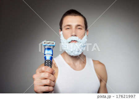 Attractive young bearded man is holding shaver 17621997