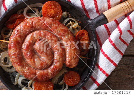 Fried sausage with onions in a pan macro top view Fried sausage with onions in a pan macro top view 17631217