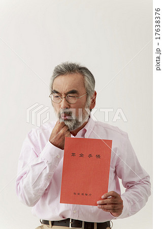 年金手帳を見せるシニア男性 年金手帳を見せるシニア男性 17638376