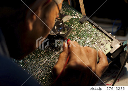 Engineer Looking at a Motherboard of an Analog TV 17643286