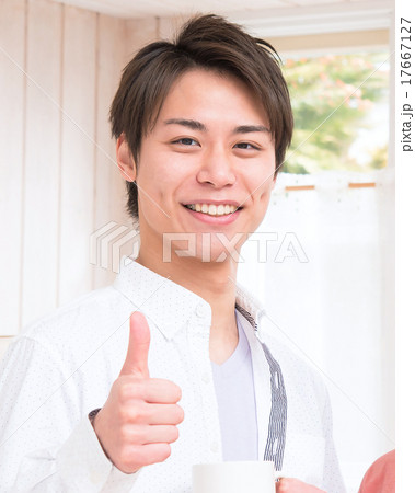 アップ 笑顔でグッドサインをする若い男性の写真素材 アップ 笑顔でグッドサインをする若い男性の写真素材