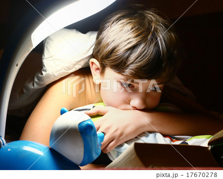 preteen handsome boy read book with lamp preteen handsome boy read book with lamp 17670278