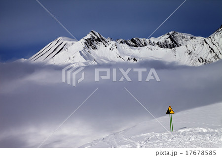 Warning sing on ski slope and mountains in fog Warning sing on ski slope and mountains in fog 17678585