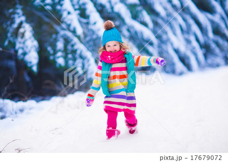 Little girl playing in snowy winter forest Little girl playing in snowy winter forest 17679072