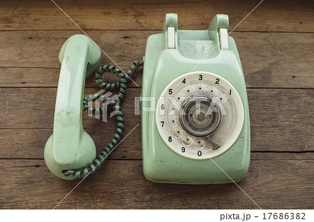 Green vintage telephone on brown wood desk 17686382