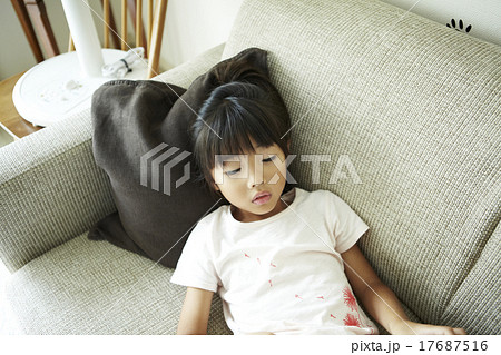 ソファに寝る女の子の写真素材
