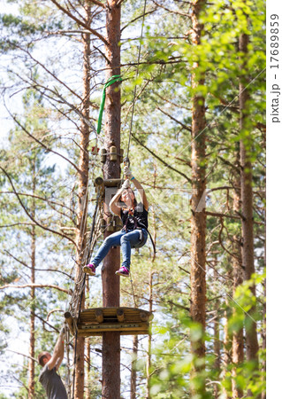 Young brave woman climbing in adventure rope park 17689859