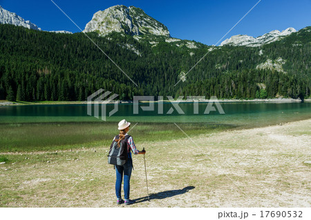 Woman hiker with a backpack and walking stick Woman hiker with a backpack and walking stick 17690532