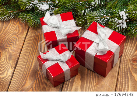 Christmas fir tree with snow and red gift boxes Christmas fir tree with snow and red gift boxes 17694248