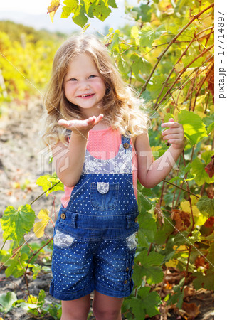 Child girl is sending blow kiss in grapes garden Child girl is sending blow kiss in grapes garden 17714897