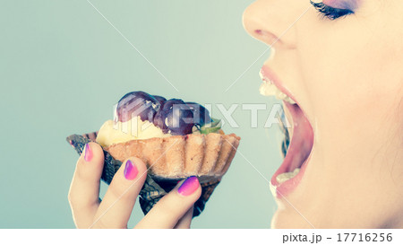 woman face profile open mouth eating cake 17716256