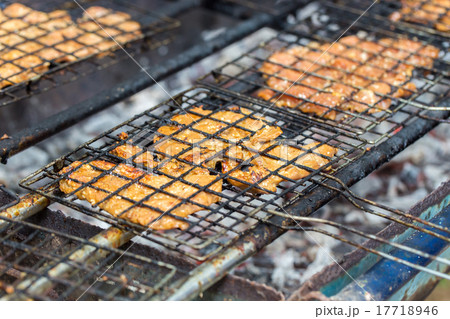 pork chops getting grilled on grill with flames. 17718946
