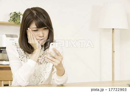 困り顔でスマホを使う女性 17722903