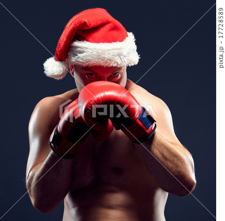Christmas fitness boxer wearing santa hat boxing on black background Christmas fitness boxer wearing santa hat boxing on black background 17728589