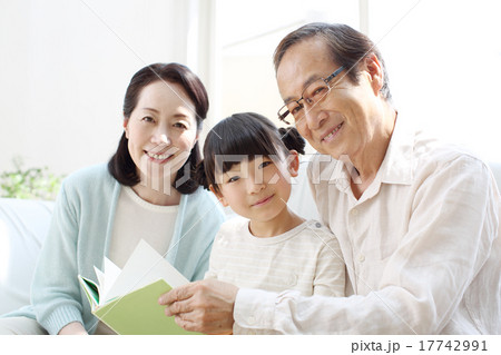 リビングで絵本を読む孫とシニア 17742991