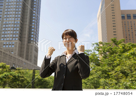 ビジネスウーマン 就活 汎用 屋外 青空 新宿高層ビル街 ガッツポーズ 叫ぶの写真素材