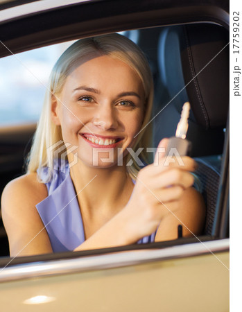 happy woman getting car key in auto show or salon 17759202