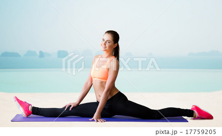smiling woman doing splits over sea and pool 17759205