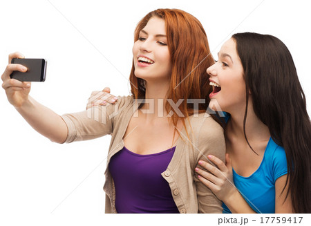 two smiling teenagers with smartphone 17759417