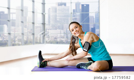 smiling woman stretching leg on mat over gym smiling woman stretching leg on mat over gym 17759582