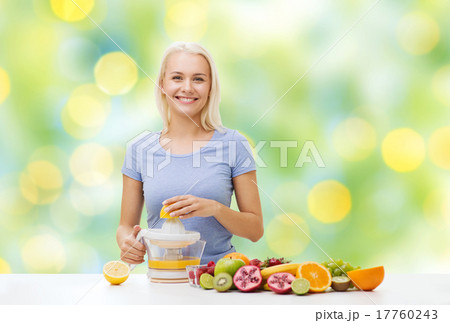 smiling woman squeezing fruit juice 17760243