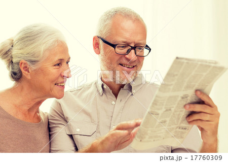 happy senior couple reading newspaper at home happy senior couple reading newspaper at home 17760309