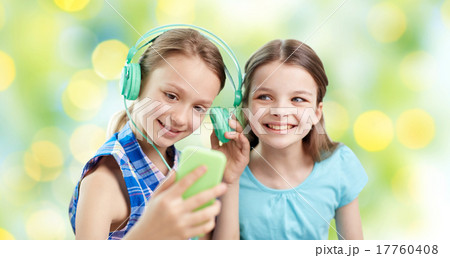 happy girls with smartphone and headphones 17760408