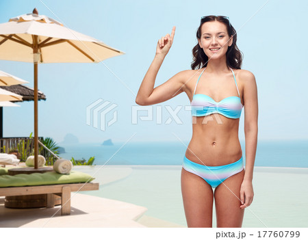 happy woman in bikini swimsuit pointing finger up 17760799