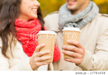 smiling couple with coffee cups in autumn park smiling couple with coffee cups in autumn park 17761038