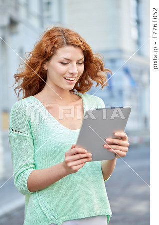 smiling teenage girl with tablet pc on city street 17761052