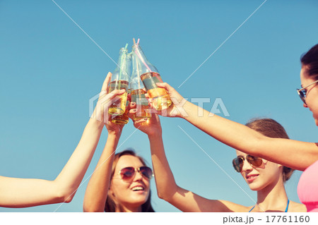 close up of happy young women clinking bottles close up of happy young women clinking bottles 17761160