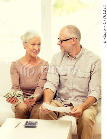 senior couple with money and calculator at home senior couple with money and calculator at home 17761227