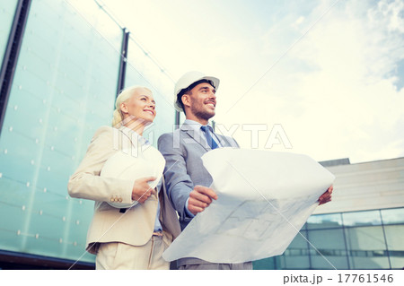 smiling businessmen with blueprint and helmets smiling businessmen with blueprint and helmets 17761546