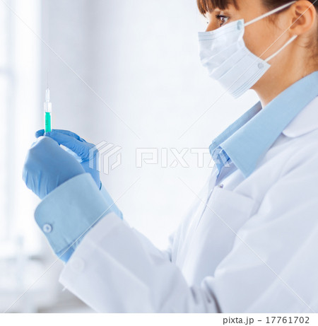 female doctor holding syringe with injection 17761702