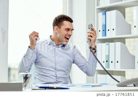 furious businessman calling on phone in office 17761851