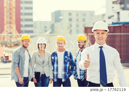 group of smiling builders in hardhats outdoors 17762119