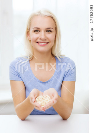 happy woman holding pills or capsules at home 17762693
