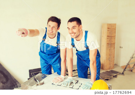 smiling builders with blueprint 17762694