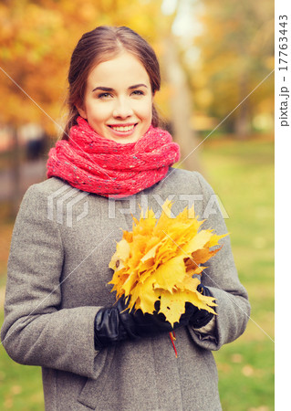 smiling woman with bunch of leaves in autumn park smiling woman with bunch of leaves in autumn park 17763443